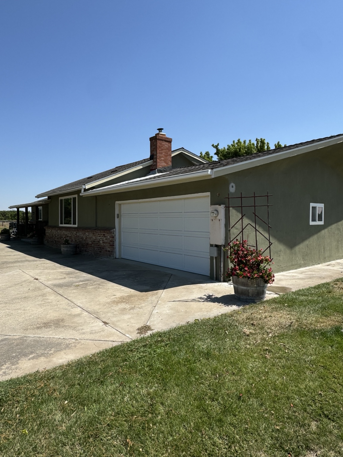 Green exterior renovation with garage, roofline, and driveway.